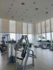 a gym with cardio equipment in a building with windows at Vinson Suites at Platinum KLCC in Kuala Lumpur