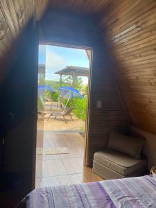 Zimmer mit einem Bett und einer Terrasse mit Sonnenschirmen in der Unterkunft Chácara Recanto das Aves in Pilar do Sul