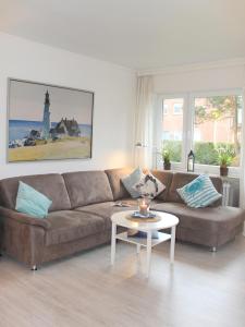 un soggiorno con divano marrone e tavolo di Ferienwohnung Strandfee, App 01 in ruhiger strandnaher Lage a Grömitz