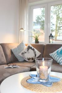 un soggiorno con divano e una candela sul tavolo di Ferienwohnung Strandfee, App 01 in ruhiger strandnaher Lage a Grömitz