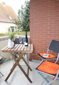 un tavolo da picnic con due sedie e una bottiglia di vino di Ferienwohnung Strandfee, App 01 in ruhiger strandnaher Lage a Grömitz