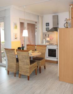 una cucina e una sala da pranzo con tavolo e sedie di Ferienwohnung Strandfee, App 01 in ruhiger strandnaher Lage a Grömitz