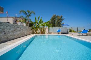 - une piscine avec des chaises bleues dans une maison dans l'établissement holiday inn endless summer, à Alcamo