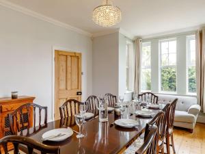 uma sala de jantar com uma mesa de madeira e cadeiras em 5 Bed in Sawtry 86894 em Sawtry