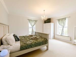 a bedroom with a bed and a chandelier at 5 Bed in Sawtry 86894 in Sawtry