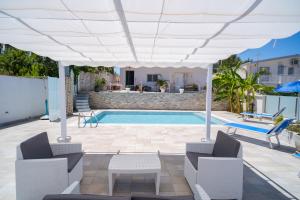 une terrasse avec une piscine et un parasol blanc dans l'établissement holiday inn endless summer, à Alcamo
