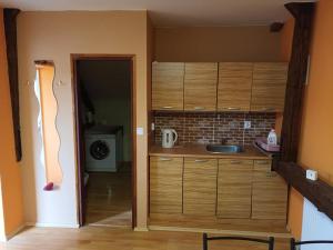 a kitchen with wooden cabinets and a door to a room at HospůdkaU Straků in Dyjákovice +6 photos