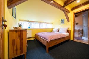 a bedroom with a bed in a yellow room at Penzion Na Výšinkách, Jetřichovice, České Švýcarsko in Jetřichovice