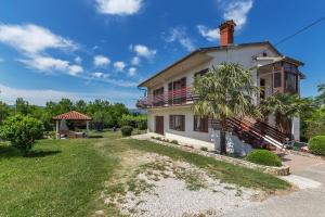 a house with a palm tree in front of it at House FELICIA in Kršan