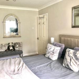 a bedroom with a bed and a dog sitting on a chair at The number one in Henley on Thames