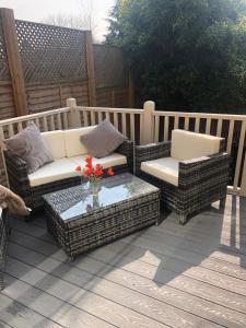 a patio with two wicker chairs and a coffee table at The number one in Henley on Thames