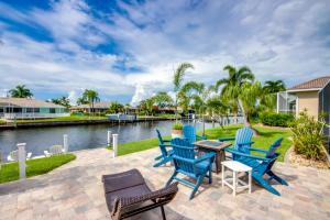 a patio with chairs and tables next to the water at Punta Gorda Getaway with Canal Access and Lanai! in Punta Gorda