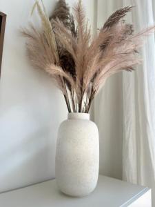 a white vase with feathers in it on a table at Amselnest - b42499 in Rimsting