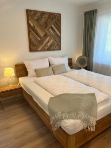 ein Schlafzimmer mit einem großen Bett mit einem Holzrahmen in der Unterkunft Amselnest - b42499 in Rimsting
