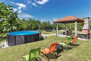 einen Hinterhof mit einem Pool, Stühlen und einem Pavillon in der Unterkunft House FELICIA in Kršan