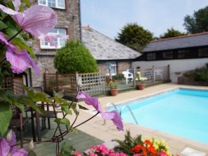 a house with a swimming pool with purple flowers at 2 Bed in Westward Ho 46824 in Westward Ho