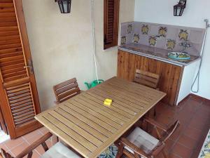 リーパリにあるEoliando Case per Vacanze - Lipari Mareの木製テーブルと椅子付きのキッチン