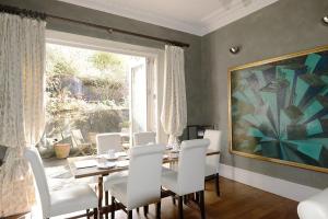 a dining room with a table and chairs and a painting at The Cloudesley Guesthouse in Hastings