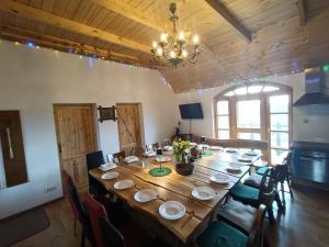 Folwark Kuźniaki-Agroturystyka i Konie, Gorąca Bania في Strawczyn: غرفة طعام مع طاولة وكراسي خشبية كبيرة