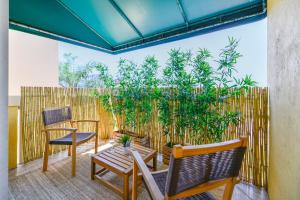 a patio with chairs and a fence with plants at Lux Condo at Yacht Club 10 min from Beach in Miami