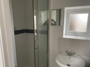 a bathroom with a shower and a sink at Charming 3 bedroom flint cottage in Lakenheath
