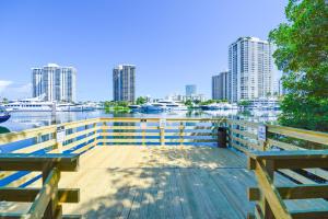 a dock with benches and a river with tall buildings at Lux Condo at Yacht Club 10 min from Beach in Miami