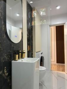a bathroom with a sink and a toilet and a mirror at LUXURY EST ONE in Drobeta-Turnu Severin