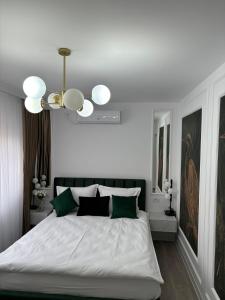a bedroom with a large white bed with green pillows at LUXURY EST ONE in Drobeta-Turnu Severin