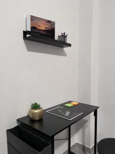 a black desk with a tv on a wall at Ale Apartment in Rome