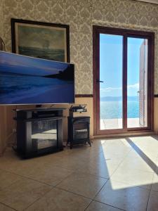 a living room with a large flat screen tv at Villa Rosa in SantʼElia