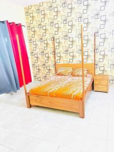 a bed with a wooden frame in a room at Timba-Day229 in Abomey-Calavi