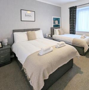 a bedroom with two beds with towels on them at Erradale in Campbeltown