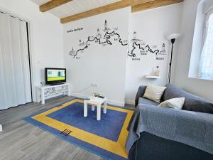 a living room with a couch and a tv at Casa de Lupa - Camariñas - Costa da Morte in A Coruña