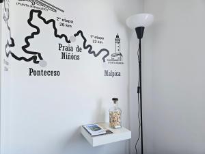 a floor lamp next to a wall with a map at Casa de Lupa - Camariñas - Costa da Morte in A Coruña
