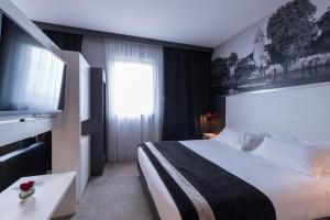 Postel nebo postele na pokoji v ubytování Hôtel des Lumières Lyon Meyzieu Arena Stadium