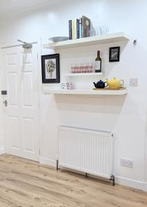 a room with white walls and a radiator and shelves at Erradale in Campbeltown