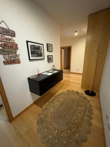 ein Wohnzimmer mit einem Teppich auf einem Holzboden in der Unterkunft Premium Apartment at Quinta da Portela - Coimbra in Coimbra