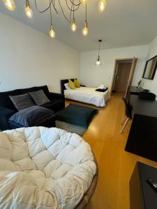 ein Wohnzimmer mit einem Sofa und einem Bett in der Unterkunft Premium Apartment at Quinta da Portela - Coimbra in Coimbra