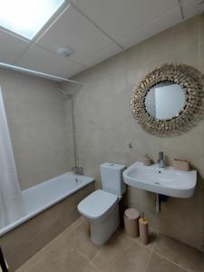 ein Badezimmer mit einem WC, einem Waschbecken und einem Spiegel in der Unterkunft Apartamento La Invencible Mojacar 1ª Línea Playa in Mojácar