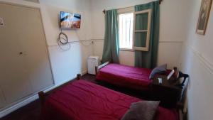 1 Schlafzimmer mit 2 Betten und einem Fenster in der Unterkunft Hostal El Encuentro in Mendoza