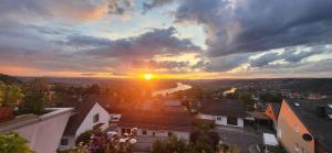einen Blick auf den Sonnenuntergang von einer Stadt in der Unterkunft Rheinblick am Rheinsteig Urbar-Koblenz in Urbar