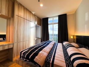 a bedroom with a large bed with a large window at PREMIER RESIDENCES @Formosa Residence Nagoya in Nagoya