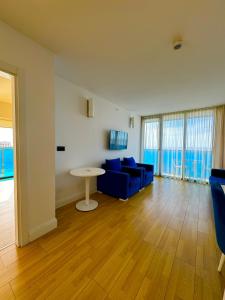 巴統的住宿－Luxsor Rooms In Orbi City，客厅配有蓝色的沙发和桌子