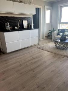 a living room with white cabinets and a wooden floor at Koselig leilighet på Nordstrand/Lambertseter, Oslo in Oslo