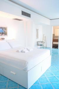 Cama blanca en habitación con suelo azul en Fountain House Sorrento en Sant'Agnello