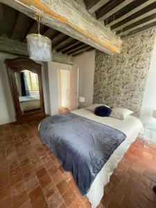 a bedroom with a large bed in a stone wall at Gîte La Bancale in Lormes