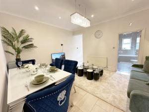 a dining room and living room with a table and chairs at Enchanting 3Bed, 2 Reception Apartment w/ Private Garden & Parking in Ilford in Barking