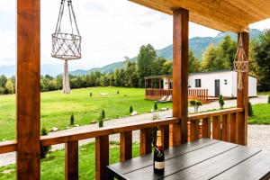 a bottle of wine sitting on a table on a porch at RAI Lodges Bran - Predelut in Bran