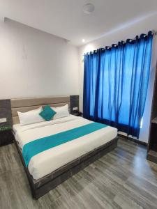 1 dormitorio con 1 cama grande y cortinas azules en Hotel The Restu And Restaurant 300 Meter From Golden Temple en Amritsar