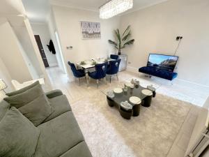 a living room with a couch and a table at Enchanting 3Bed, 2 Reception Apartment w/ Private Garden & Parking in Ilford in Barking